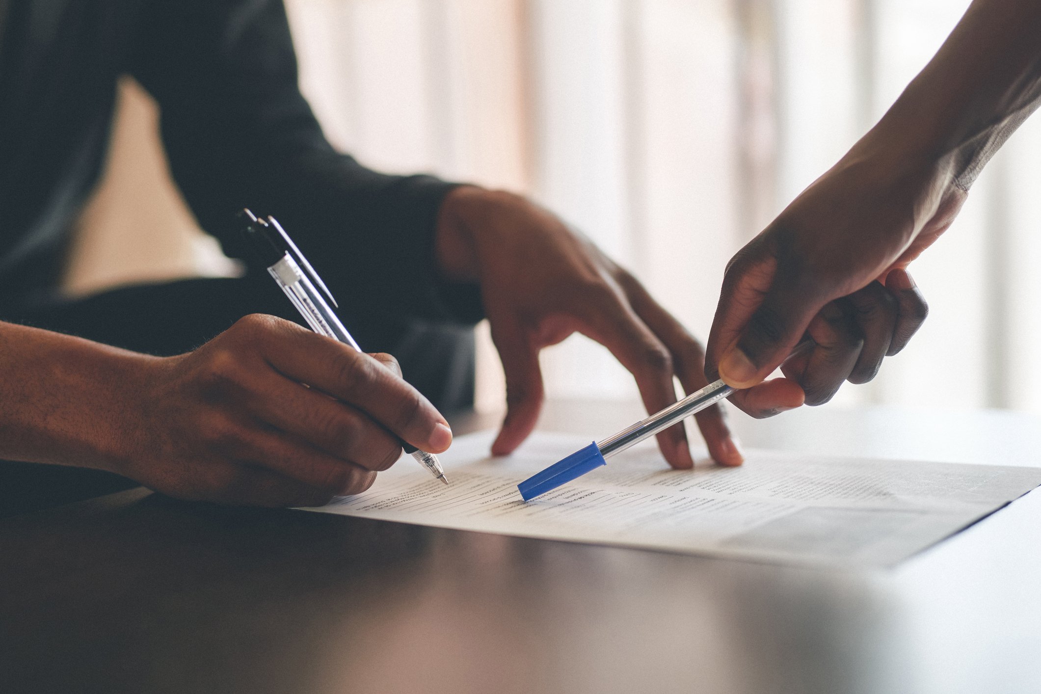 Two People Filling Out A Paper